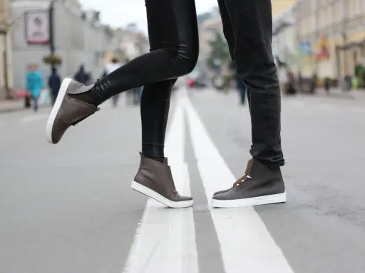 Para, gdy buty farbują od środka, co zrobić? Stylowe brązowe trampki na ulicy.