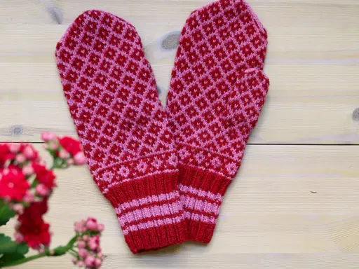 Två stickade vantar i rött och rosa med diamantmönster. Perfekt för dig som söker stickbeskrivningar gratis för att skapa egna.