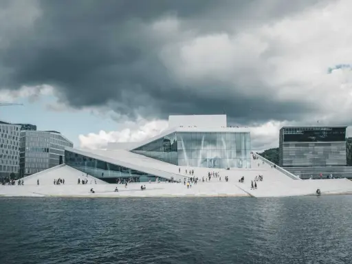 Nowoczesna architektura Opery w Oslo, gdzie prawo jante jest widoczne w kaskadowych, białych dachach schodzących do wody.
