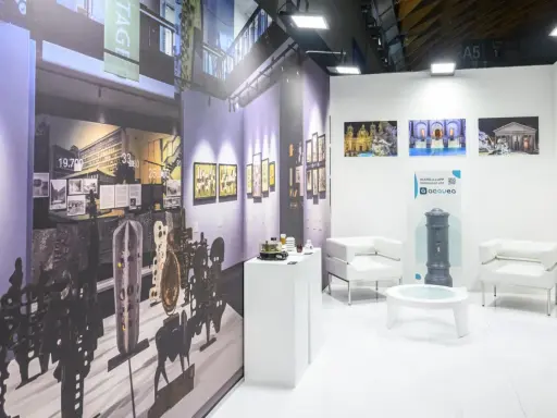 Stand espositivo con opere d'arte e arredi moderni, pronto per il meeting Rimini 2026.