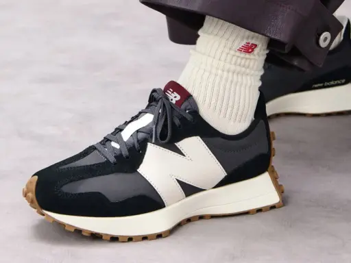 Jak wiązać sznurówki w sneakersach New Balance? Zobacz, jak elegancko prezentują się te ciemne buty z białym logo.