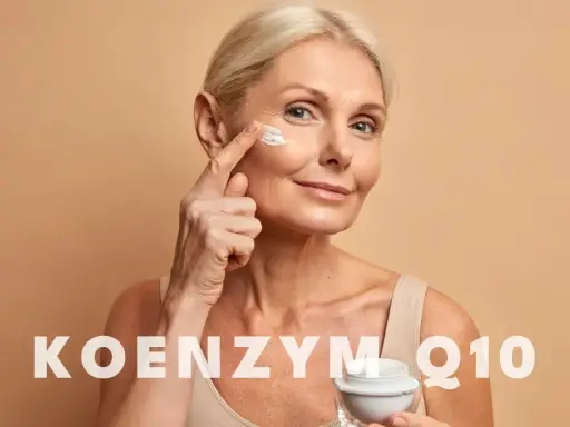 Kobieta aplikuje krem z koenzymem Q10 na skórę wokół oczu. Koenzym Q10 na co? Na odmłodzenie i regenerację.