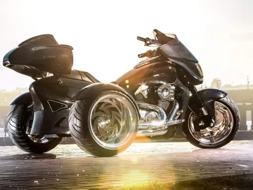 Czarny, lśniący motocykl trójkołowy na kat B. Z imponującymi felgami i sportowym wyglądem, gotowy na podbój dróg.