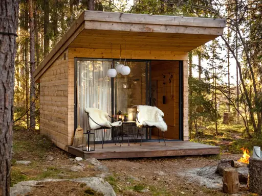 Mysig koja i skogen, perfekt för att bo i som ett skogshotell. Två fårskinnsbeklädda stolar på altanen inbjuder till avkoppling.