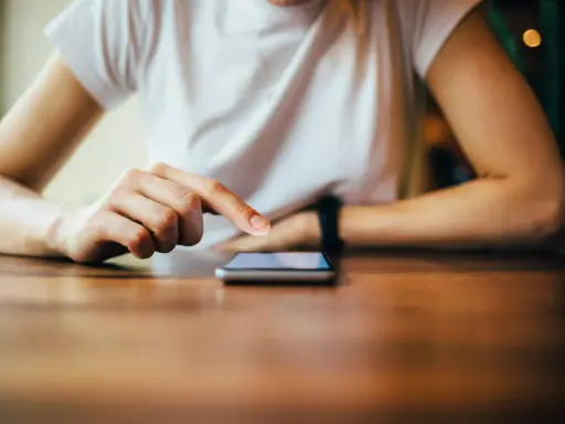 Dłoń dotyka ekranu telefonu, być może wykonując twardy reset Xiaomi.