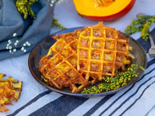 Gaufres dorées et croustillantes, une délicieuse gaufre potimarron salé, garnie de petites fleurs jaunes.