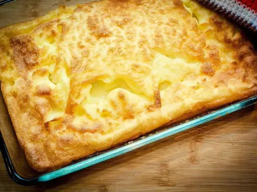 En gyllene, fluffig ugnspannkaka i en glasform, redo att serveras. Ett perfekt ugnspannkaka recept för en mysig middag.