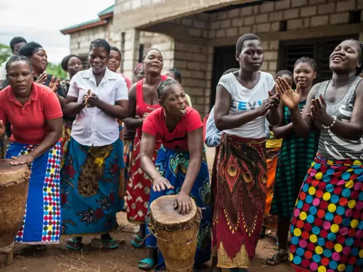 Des femmes africaines jouent du tambour et chantent, un parfait synonyme de sororité.