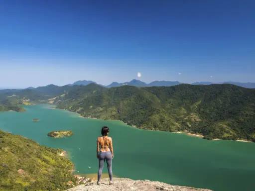 Frauenblick auf die grüne Bucht von Paraty, Brasilien, mit bewaldeten Bergen und Inseln.
