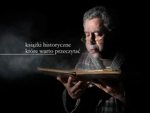 Starszy mężczyzna w okularach pochyla się nad starą księgą, zanurzając się w lekturze. Wokół unosi się pył, podkreślając atmosferę tajemnicy i wiedzy zawartej w książkach historycznych.