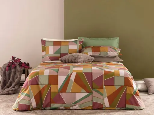Un letto con copripiumino geometrico dai colori caldi e terrosi. Un perfetto abbinamento colori camera da letto per un tocco moderno e accogliente.