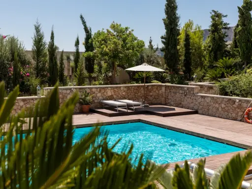 Piscine luxueuse avec terrasse en bois, transats, parasol et bouée. La protection électrique de la piscine est assurée pour une baignade en toute sécurité.