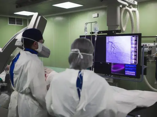 Lekarze analizują obraz tętnic wieńcowych na monitorze, oceniając, czy koronarografia jest bezpieczna i skuteczna.
