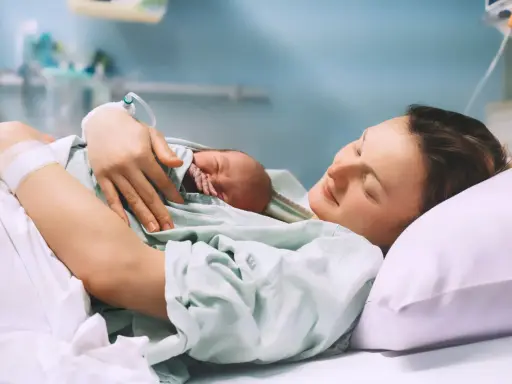 Szczęśliwa mama tuli noworodka po porodzie, czując ulgę po znieczuleniu.