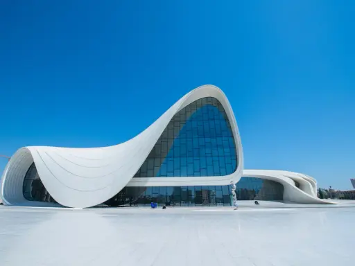 Impresionante centro de congresos con fluidas estructuras diseñadas por Zaha Hadid, bajo un cielo azul intenso.