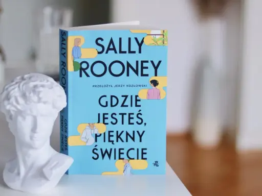 Biała rzeźba popiersia obok książki Sally Rooney "Gdzie jesteś, piękny świecie".