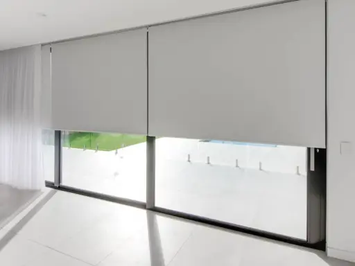 Elegantes persianas enrollables grises ofrecen soluciones para ventanas con mucho sol, bloqueando el deslumbramiento y el calor.