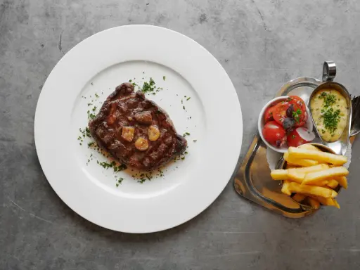 En saftig biff med vitlök, pommes frites, tomatsallad och bearnaisesås. En måltid som får en att vilja skriva restaurang Prinsens recensioner.