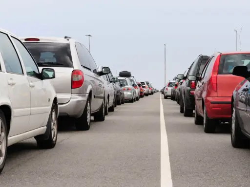 Fila de coches en carretera. Evita la multa por adelantar en línea continua.