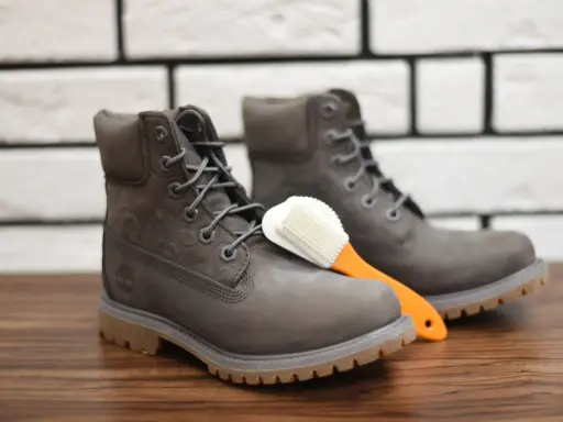 Szare Timberlandy i szczoteczka do czyszczenia. Dowiedz się, czym czyścić timberlandy, by służyły latami.