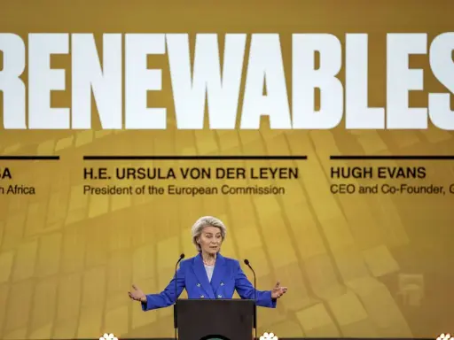 Ursula von der Leyen spricht über erneuerbare Energien. Ein Vergleich der europäischen Initiativen ist im Hintergrund zu sehen.