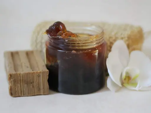 Un pot de savon noir, une barre de savon, une fleur d'orchidée et une éponge. Idéal pour un insecticide naturel à base de savon noir, bicarbonate et autres ingrédients.