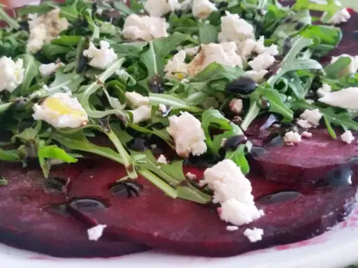 Carpaccio z buraka z fetą i rukolą, polane sosem balsamicznym.