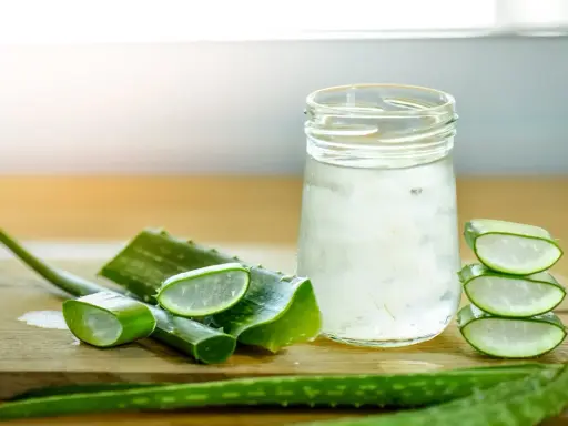 Tranches d'aloe vera et un verre rempli de sa pulpe translucide, évoquant les nombreux aloe vera bienfaits pour la santé et la peau.