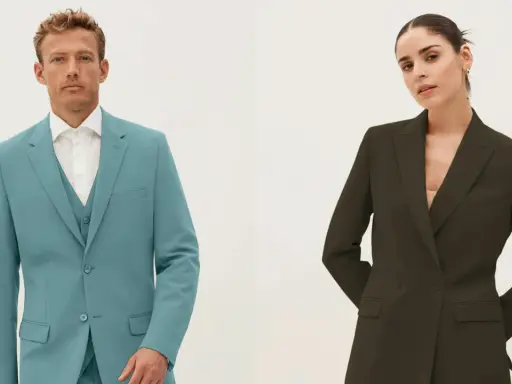 Man in teal single-breasted suit with vest, woman in dark green double-breasted blazer.