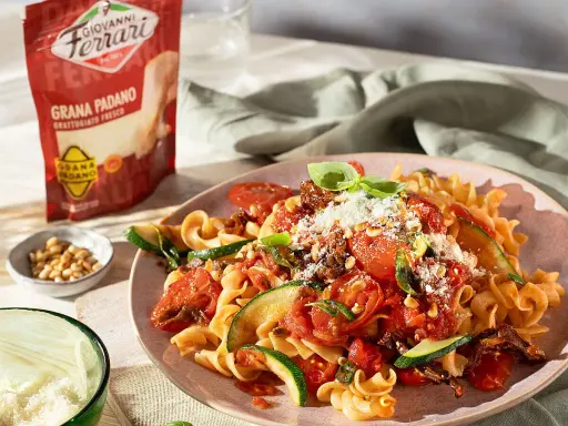 Pasta mit Tomaten, Zucchini und Pinienkernen, bestreut mit Grana Padano. Diese Parmesan-Sorten verfeinern jedes Gericht.