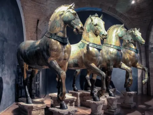 Les célèbres chevaux de Saint-Marc, statues de bronze patiné, se dressent fièrement dans un musée, leurs corps musclés capturant l'essence de la puissance antique.