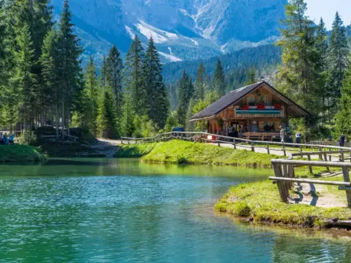 Rifugio alpino in Italia, con lago cristallino e montagne sullo sfondo. Perfetto per una vacanza in montagna Italia.