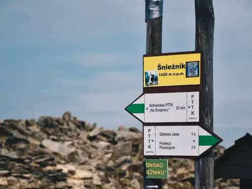 Znak drogowskazów na Śnieżnik, 1426 m n.p.m. Wskazuje drogę do schroniska "Na Śnieżniku" i na Przełęcz Płoszczynę.