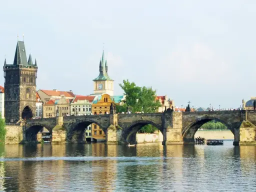 Most Karola w Pradze, z wieżą i zabytkowymi budynkami. To piękne informacje o Czechach.