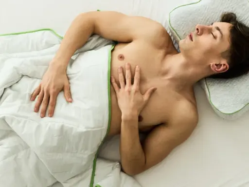 Ein Mann schläft entspannt unter einer Decke, ohne Unterhose schlafen für maximalen Komfort.