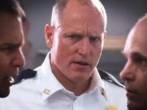 Woody Harrelson i en vit skjorta, omgiven av andra män. En scen från filmer och tv-program med Woody Harrelson.