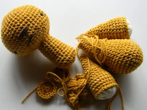 Piezas de amigurumi de One Piece en proceso, con hilo amarillo y detalles bordados.