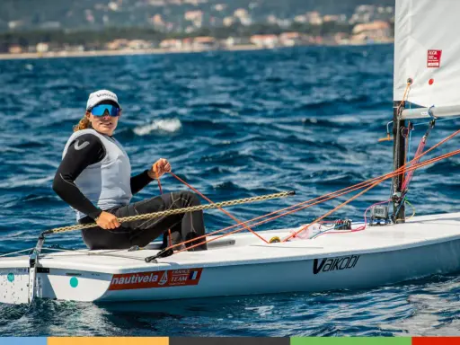 Louise Cervera, navigatrice française, manœuvre son dériveur ILCA sur une mer bleue. Elle porte une casquette et des lunettes de soleil.