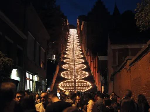 Beleuchtete Treppe in Büren bei Nacht, umgeben von Menschen und Gebäuden.