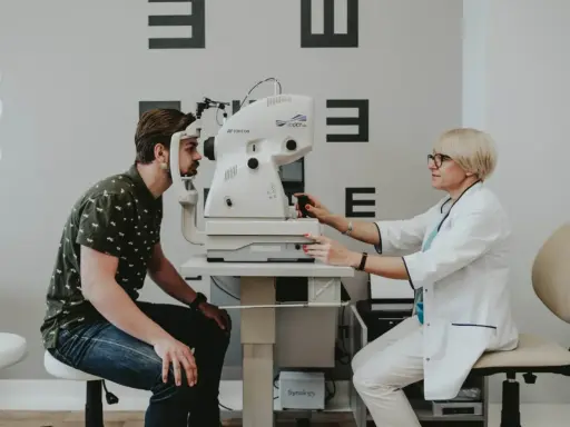 Okulista przeprowadza badanie refrakcji u pacjenta za pomocą nowoczesnego sprzętu.