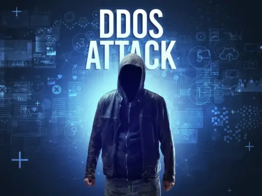 Anonimowa postać w kapturze na tle cyfrowych danych. Wielki napis "DDOS ATTACK" wyjaśnia, ddos co to.