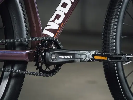 Zbliżenie na rowerowy mechanizm korbowy SRAM i łańcuch. Tabela przełożeń rowerowych jest kluczowa dla płynnej jazdy.