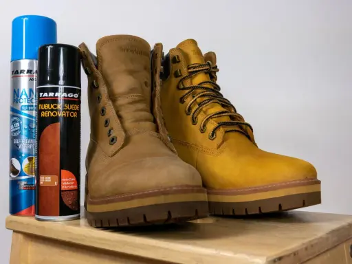 Dwa buty Timberland i dwa preparaty do pielęgnacji: jak czyścić buty z nubuku, by wyglądały jak nowe.