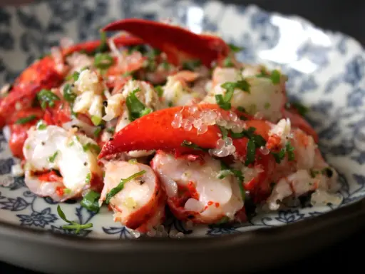 Homard frais servi avec des perles de citron caviar, une recette raffinée pour un plat d'exception.