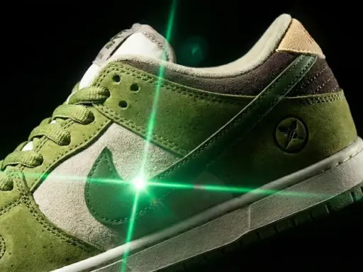 Zielone buty Nike SB Dunk z oryginalną metką, oświetlone zielonym laserem.
