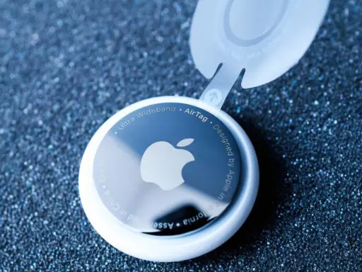 Biały AirTag z logo Apple, pokazujący, jak działa AirTag. Urządzenie z technologią Ultra Wideband.