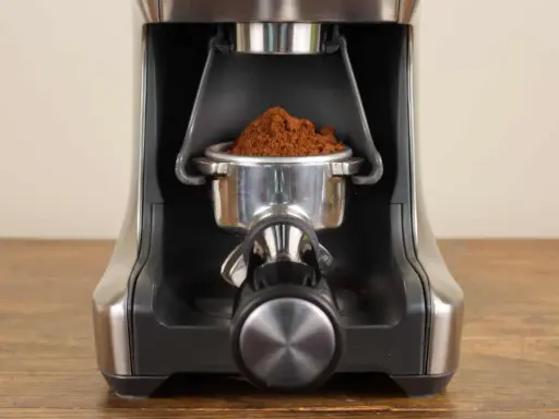 Nahaufnahme des Siebträgers mit frisch gemahlenem Kaffee, bereit zur Einstellung des Sage Smart Grinder Pro.