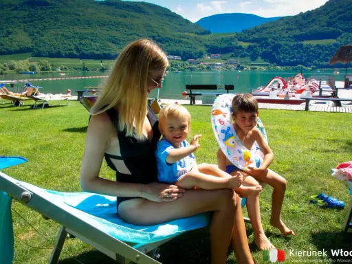 Rodzina odpoczywa nad jeziorem Lago di Caldaro. Słońce, zieleń i woda tworzą idealne wakacje.