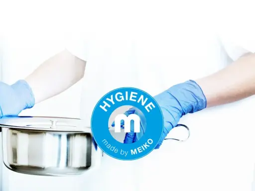 Mani guantate presentano una padella metallica, pronta per essere usata. Il logo MEIKO sottolinea l'igiene.