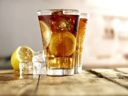 Dwa orzeźwiające long island iced tea z plasterkami cytryny i lodem, gotowe do degustacji.